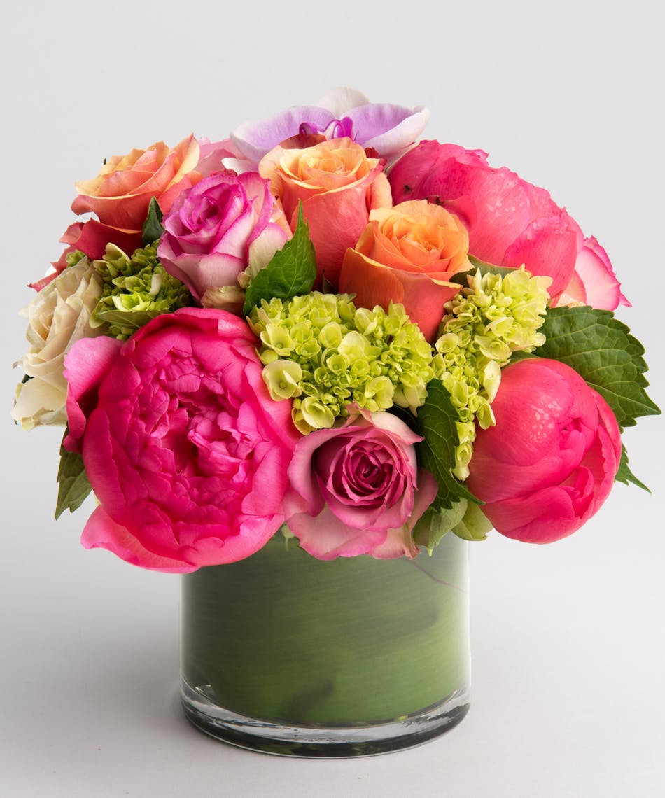 arrangement of coral peony with pink and orange roses