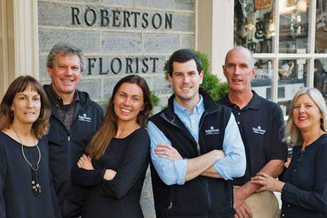 Our skilled leadership team, posing outside the front doors of our floral showroom